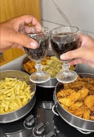 Duas pessoas brindando com vinho junto a pratos de comida, no depoimento de Patricia R.
