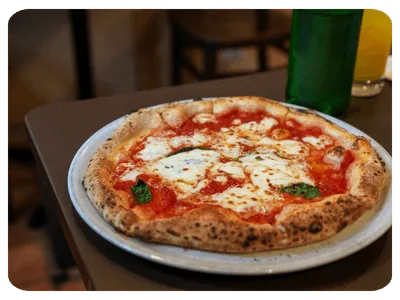 Pizza com queijo, molho de tomate e manjericão